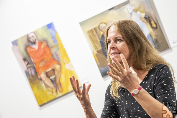 Gestenreich erläutert Mona Dia ihre Kunstwerke, die Bestandteil der Ausstellung „50 Jahre KOMMernich“ in der Rathausgalerie sind. Foto: Ronald Larmann/pp/Agentur ProfiPress
