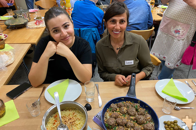 Zufriedene Mienen am reichlich gedeckten Tisch: Gastköchin Joumana El-Khodr (r.) und ihre Tochter Enji Msatat freuen sich über den gelungenen Kochabend.  Foto: Thomas Weber/pp/Agentur ProfiPress