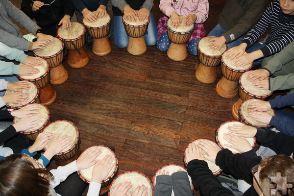Kommerner Grundschüler haben ein Kreis aus 17 afrikanischen Handtrommeln gebildet, auf denen sie der Delegation des Kinderschutzbundes vorspielten, wie Rhythmus geht. Foto: Privat/pp/Agentur ProfiPress