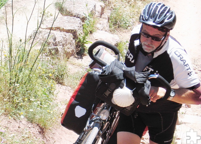 Wer sein Fahrrad liebt, schiebt – besonders an Steilhängen: Jakobspilger Robert Ohlerth 2014 auf dem portugiesischbn „Camino“ zum Apostelgrab in Santiago de Compostela. Foto: Privat/pp/Agentur ProfiPress