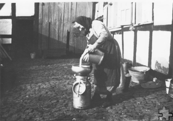 Helene Hörnchen schüttet in einem Innenhof Mich durch eine „Seijl“ in eine Kanne. Foto: Artur Stoff/Sammlung Otto Stoff/pp/Agentur ProfiPress