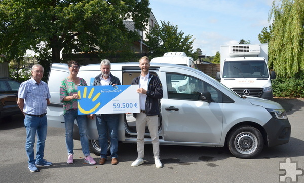 Vor dem neuen E-Auto: Mechernicher Tafel-Mitarbeiter (v. l.) Volker Nüßmann (stellvertretender Vorsitzender), Manuela Pütz (Kassiererin) und Hans-Peter Buhs (Geschäftsführer) nahmen glücklich einen symbolischen Spendenscheck über 59.500 Euro von Nils Detering, einem Repräsentanten der „Deutschen Fernsehlotterie“, entgegen. Foto: Henri Grüger/pp/Agentur ProfiPress