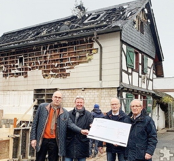 Dr. Ludwig Veltmann (v.l.) und Manni Poth vom Rotaryclub bei der Spendenübergabe an Bürgermeister Dr. Hans-Peter Schick und den Kommerner Ortsbürgermeister Rolf Jaeck vor dem ausgebrannten Haus der Opladens in Kommern. Foto: Privat/pp/Archiv Agentur ProfiPress