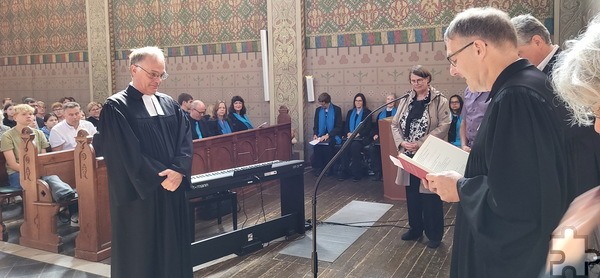 Synodalassessor Pfarrer Martin Obrikat aus Aachen (r.) entpflichtet den evangelischen Pfarrer Dr. Michael Stöhr, rechts im Hintergrund Stöhrs Ehefrau Sigrid Frentzen-Stöhr, die ebenfalls Pfarrerin ist. Foto: Manfred Lang/pp/Agentur ProfiPress