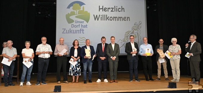 Beim kreisweiten Wettbewerb „Unser Dorf hat Zukunft“ erreichte Kallmuth Silber. Ortsbürgermeister Robert Ohlert und Ortskartell-Vorstand Rita Baumann (3. u. 4. v. r.) nahmen den Preis entgegen. Mit im Boot waren Buir, Frohngau, Kallmuth, Nettersheim, Roderath, Scheven, Sieberath, die Dörfergemeinschaft Thürne, Tondorf und Zingsheim. Moderiert wurde die Verleihung von Radio-Euskirchen-Chefredakteur Norbert Jeub (r.). Foto: Henri Grüger/pp/Agentur ProfiPress