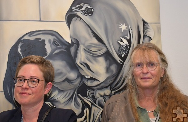 Das Bild im Hintergrund zeigt zwei bei Säureattentaten verstellte Frauen, die sich umarmen, die beiden Besucherinnen der Vernissage davor stehen symbolisch für uns Menschen in freiheitlichen Demokratien, die das Wort für die Unterdrückten und Verfolgten erheben sollen. Foto: Manfred Lang/pp/Agentur ProfiPress