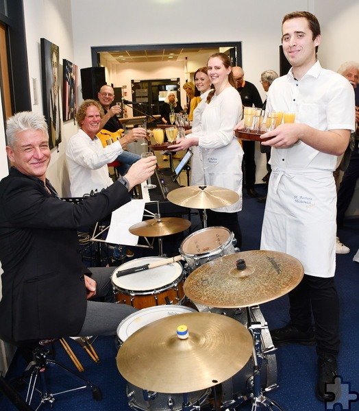 Die tadellose Bewirtung der zahlreichen Vernissage-Gäste übernahmen junge Christen der katholischen Pfarrjugendgruppe um Rebekka Narres, hier servieren sie dem Trio Uli van Staas (m). Foto: Manfred Lang/pp/Agentur ProfiPress