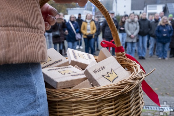 Würde unantastbar: Die Schülerinnen des Gymnasiums Am Turmhof und ihre stellvertretende Schulleiterin Rosemarie Antwerpen verteilten beim Pogromgedenkggang in Mechernich Holztäfelchen mit klarer Botschaft. Foto: Ronald Larmann/pp/Agentur ProfiPress