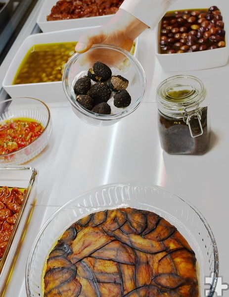 Ein Blick in die Antipasti-Theke: Artischockenböden, Auberginen-Torte, eingelegte getrocknete Tomaten, Olive Verdi alla Contadina und frische Trüffel. Foto: Manfred Lang/pp/Agentur ProfiPress