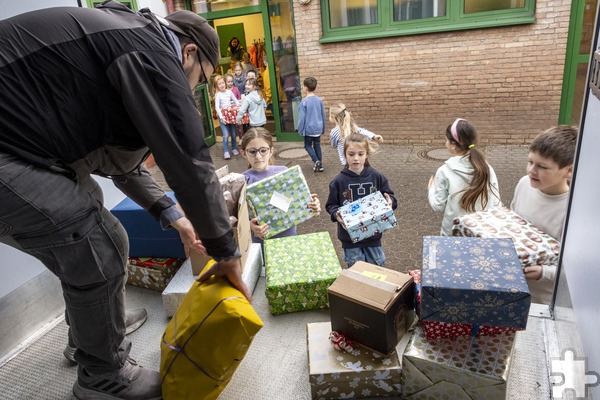 Tafel-Mitarbeiter Tim Achnitz hatte alle Hände voll zu tun, um die Pakete, die die Grundschülerinnen und Grundschüler heranschleppten, im Transporter zu verstauen. Foto: Ronald Larmann/pp/Agentur ProfiPress