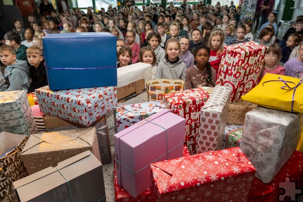 Ganz schön viele Pakete für die Tafel lagen auf der Bühne in der Lückerather Grundschule, wo die Schülerinnen und Schüler zu einer kleinen Weihnachtsfeier zusammengekommen waren. Foto: Ronald Larmann/pp/Agentur ProfiPress