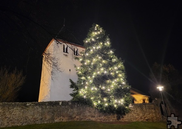 Über den Dächern von Mechernich lässt dieser naturgewachsene Tannenbaum an der Alten Kirche sein warmes Licht erstrahlen. Foto: Manfred Lang/pp/Agentur ProfiPress