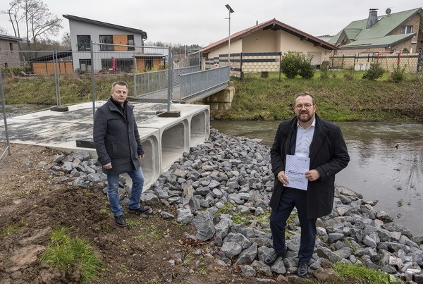 Erster Beigeordneter Thomas Hambach (r.) und Mario Dittmann, der zuständige Fachbereichsleiter, am flutbedingten Brückenneubau in Satzvey. In Bürgerversammlungen wird nun über geplante Schutzmaßnahmen informiert. Foto: Larmann/pp/Agentur ProfiPress