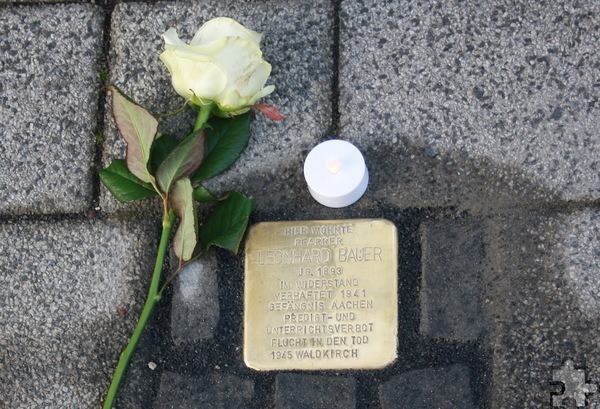 Eine weiße Rose und ein Licht haben Menschen am Stolperstein für Pfarrer Leonhard Bauer niedergelegt, um an einen wehrhaften Glaubenszeugen gegen die Nazis zu erinnern, der in seiner Verzweiflung Hand an sich selber legte und dem deshalb die Aufnahme in den Kreis zeitgenössischer Märtyrer verwehrt wird. Foto: Karl Reger/pp/Agentur ProfiPress