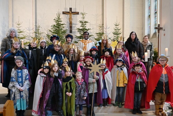 30 der 50 Sternsinger, die in Mechernich und Umgebung den Dreikönigssegen spendeten, Geld für Gleichaltrige in Not sammelten und am Vortag des Dreikönigsfestes in der Mechernicher Pfarrkirche St. Johannes Baptist mit Pfarrer Stephen Rayappan Packiam (m.) Heilige Messe feierten, mit drei Vertreterinnen des tonangebenden Familienmesskreises, links Agnes Peters, rechts Claudia Simon und Ramona Averbeck. Foto: Sabine Roggendorf/pp/Agentur ProfiPress