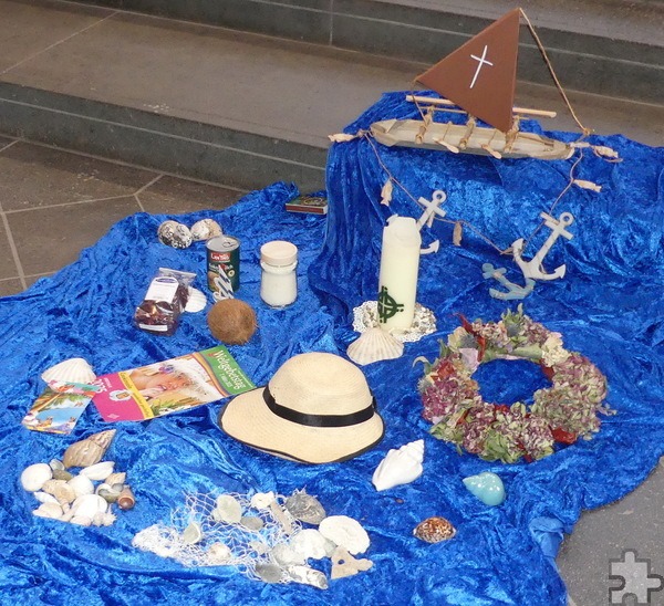 Auf einem meeresblauen Tuch vor dem Altar hatten die Organisatorinnen ein „Waka“-Boot mit Segel, Blumenkränze, Hüte aus Kokosfasern, Kokosmilch und Muscheln ausgebreitet. Foto: Franz Richter/pp/Agentur ProfiPress