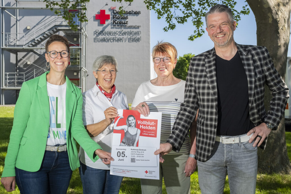 Ziehen nicht nur gemeinsam am Plakat, sondern auch an einem Strang für die nächste Blutspende am 5. Juni im Euskirchener Rotkreuz-Zentrum: Die AOK-Mitarbeiter Daniela Heider (l.) und Jürgen Schneider sowie die DRK-Ehrenamtler Angelika Gräber-Stupp (2.v.l.) und Edeltraud Engelen. Foto: Ronald Larmann/pp/Agentur ProfiPress