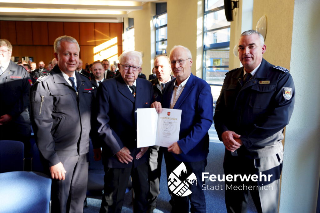 Der Leiter der Mechernicher Feuerwehr Jens Schreiber (r.), sein Stellvertreter Thomas Wolff (l.) und Bürgermeister Dr. Hans-Peter Schick übergaben bei der Jahresdienstbesprechung der Mechernicher Feuerwehr eine Urkunde für beeindruckende 70 Jahre Mitgliedschaft an Willi Prast.