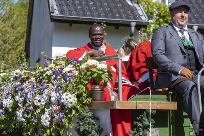 Auch Father Patrick Mwanguhya von der Mechernicher Communio in Christo genoss offenbar die Fahrt mit dem Festwagen. Foto: Ronald Larmann/pp/Agentur ProfiPress