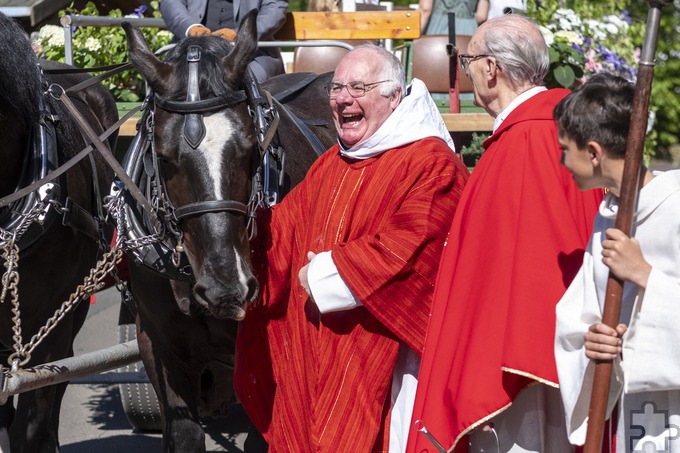 Ein herzhaftes Lachen: Pater Elias freundete sich vor der Abfahrt mit dem Festwagen mit den Kaltblütern Thor und Zeus an. Foto: Ronald Larmann/pp/Agentur ProfiPress