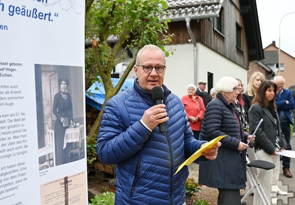 Rainer Schulz von der Projektgruppe „Forschen – Gedenken – Handeln“ stand neben einem Foto der ermordeten Veronika Höger, geb. Heinen, und einer Infotafel mit den wichtigsten Fakten zu ihrem Schicksal, als er die zahlreichen Gäste der Stolpersteinenthüllung begrüßte. Foto: Manfred Lang/pp/Agentur ProfiPress