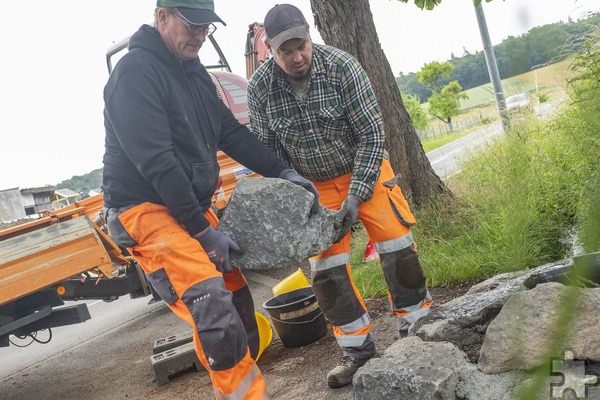 Mit schweren Natursteinen haben der stellvertretende Bauhofleiter Alexander Schröder (r.) und sein Kollege Marcel May heute die Quelle zugemauert. Foto: Ronald Larmann/pp/Agentur ProfiPress