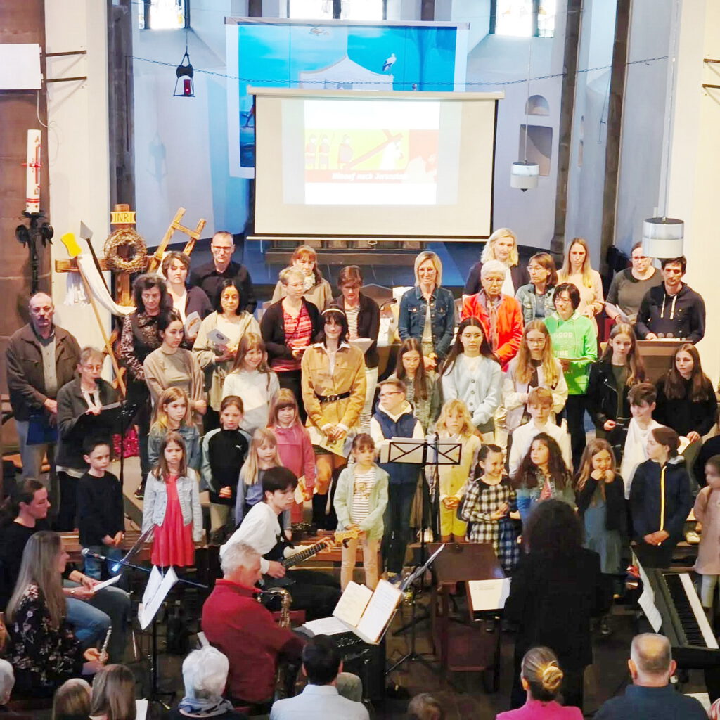 Band, Kirchen- und Kinderchor agieren beim Jugendkreuzweg gemeinsam, auf der Anzeigetafel hinter dem Altar können Liedtexte und Meditationsbilder eingespielt werden. Foto: Privat/pp/Agentur ProfiPress