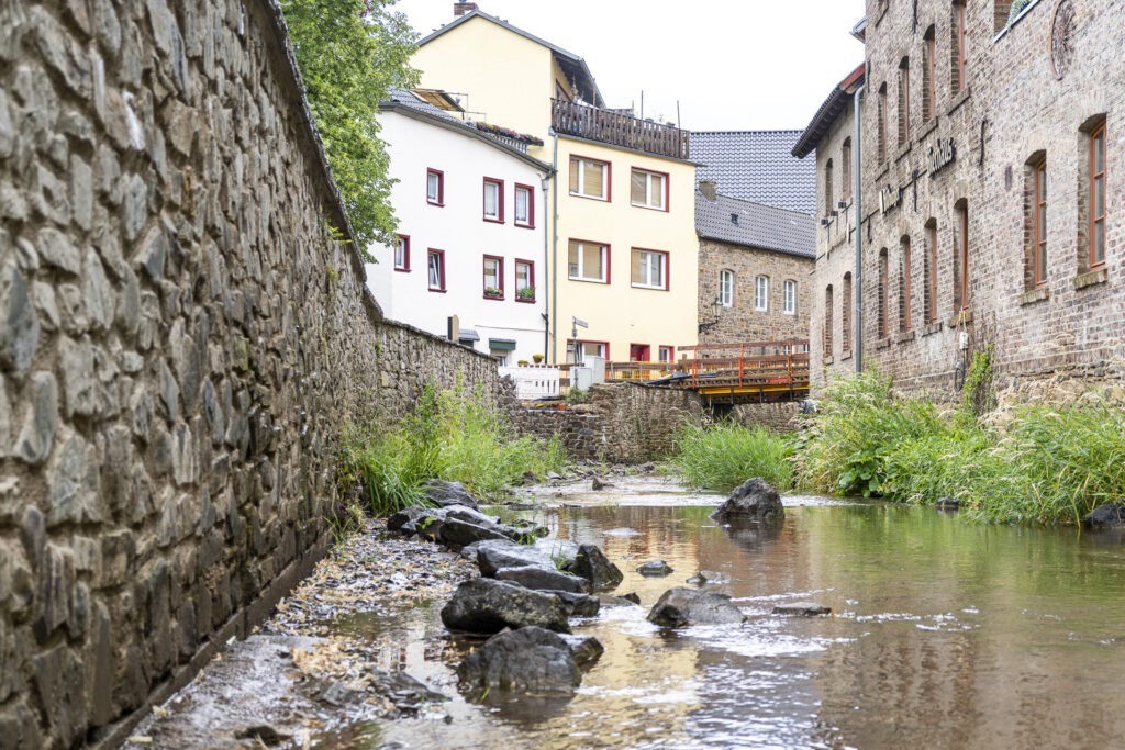 Die Fluten der Erft hatten dem Bauwerk 2021 so stark zugesetzt, dass nur ein Neubau Sinn machte. Der wird gefördert durch die „Aktion Deutschland hilft“. Im Hintergrund ist die Behelfsbrücke zu sehen. Foto: Ronald Larmann/pp/Agentur ProfiPress