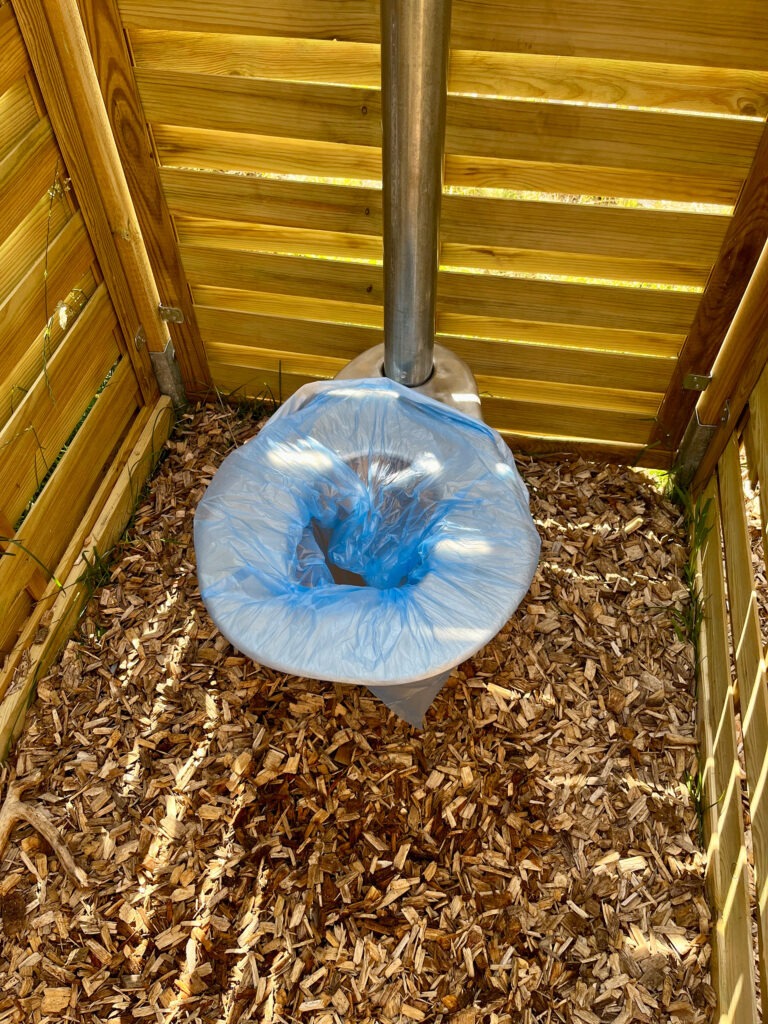 Hinter einem spiralförmigen Holzzaun verbirgt sich die ausgeklügelte Toiletten-Konstruktion. Die zu nutzende Plastiktüte ist biologisch abbaubar und kann danach verknotet entsorgt werden. Foto: Nathalie Konias/pp/Agentur ProfiPress