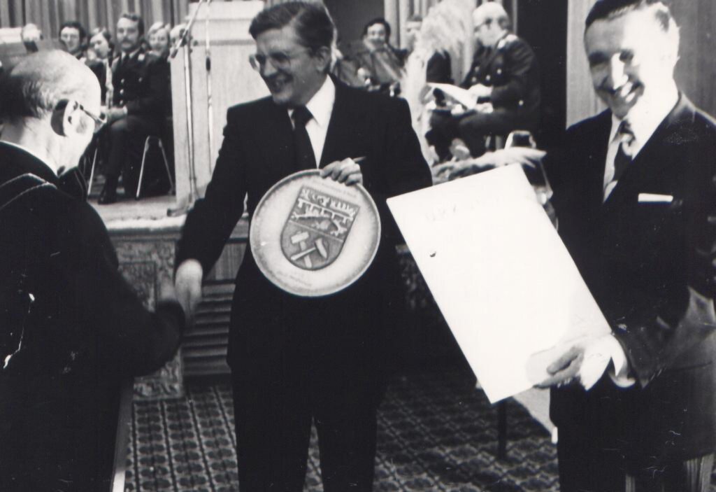 Bürgermeister Peter Giesen (l.) bedankte sich bei Innenminister Dr. Burkhard Hirsch mit einem großen Wappenteller der Stadt, während Mechernichs Stadtdirektor und Autor des Beitrags im Kreisjahrbuch, Helmut Rosen, voller Stolz die Urkunde zeigt. Foto: H.G. Nickolay/pp/Agentur ProfiPress