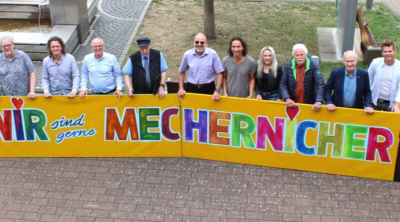 Viel Lust auf ein großes, fröhliches Stadtfest macht das knallbunte, vom Mechernicher Kurator Franz Kruse entworfene Kunstwerk, das die Musiker und Verantwortlichen nun vor dem Rathaus präsentierten. Foto: Kerstin Rottland/pp/Agentur ProfiPress