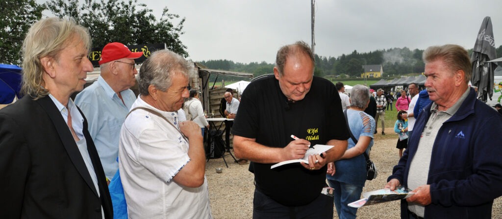 Waldis Bücher waren bei der Präsentation sofort gefragt - und er signierte sie gerne. Links Verleger Frank Steffan, rechts Peter Meurer, der Waldis Erzählungen niedergeschrieben hat. Foto: Reiner Züll/pp/Agentur ProfiPress
