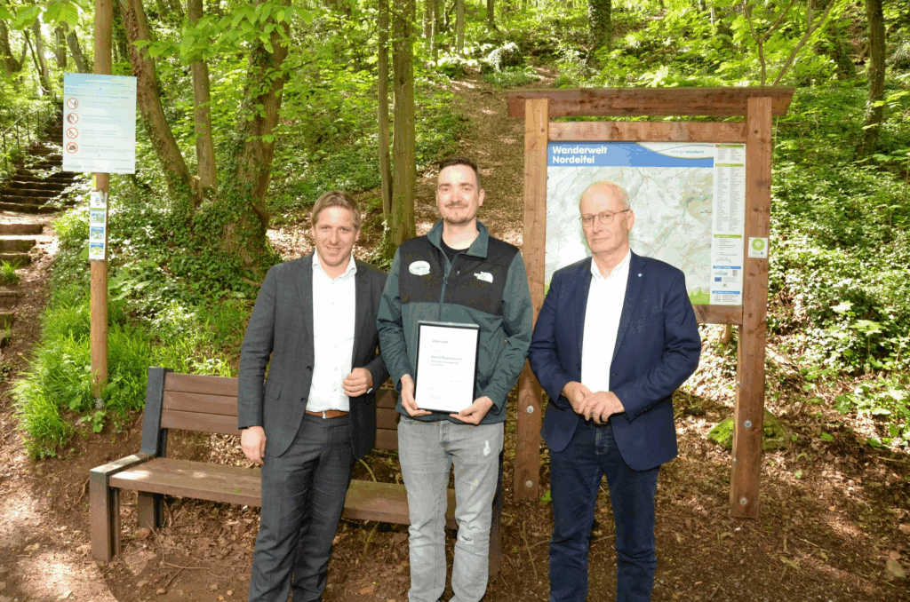 2023 erhielt David Rosenbaum (m.) von Landrat Markus Ramers (l.) und Bürgermeister Dr. Hans-Peter Schick die Auszeichnung „Ehrenamt des Monats“. Jetzt berichtet er im Nordeifel-Podcast über sein Hobby als Wegewart. Foto: Grüger/pp/Agentur ProfiPress