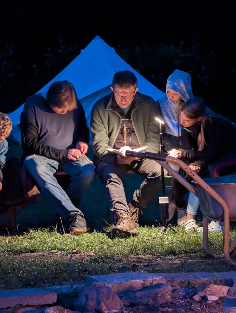 Auch ein Stück Lagertradition: Abends am Lagerfeuer liest Holger Stürmer immer aus einem zum jeweiligen Lagermotto passenden Buch vor, bevor Caroline Tesch zur Klampfe greift und gesungen wird. Foto: Stefan Studinski/pp/Agentur ProfiPress