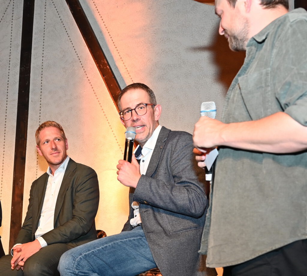 Klaus Reiferscheid, hier zwischen Landrat Ramers und Moderator Esser, erzählte, wie die VR-Bank Nordeifel bereits vor über 20 Jahren ihr Unternehmensleitbild von dem Eifelpoeten Fritz Koenn ins Eifeler Platt übersetzen ließ und bis heute neben der hochdeutschen Variante auch verwendet. Foto: Manfred Lang/pp/Agentur ProfiPress