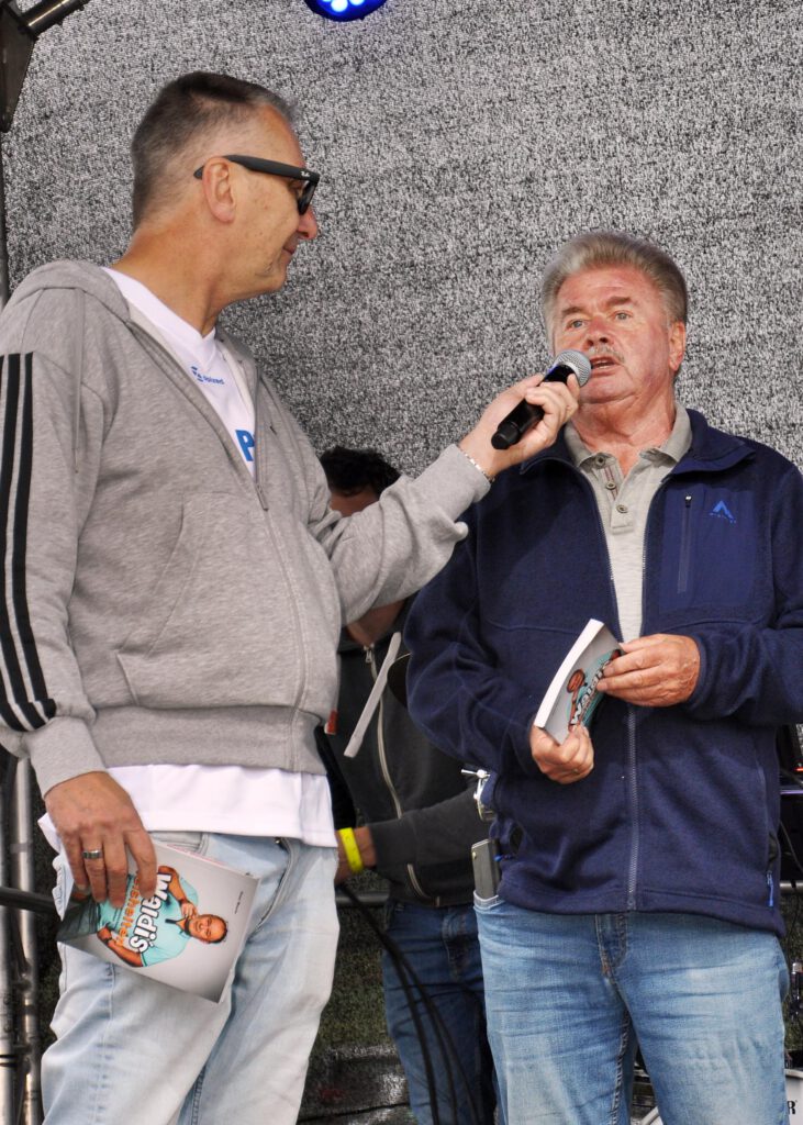 Peter Meurer (r.) schildert Moderator Manuel Zeh die Zusammenarbeit mit seinem Nachbarn Walter Lehnertz, nach dessen Erzählungen das Buch „Waldi´s Weisheiten“ entstand. Foto: Reiner Züll/pp/Agentur ProfiPress