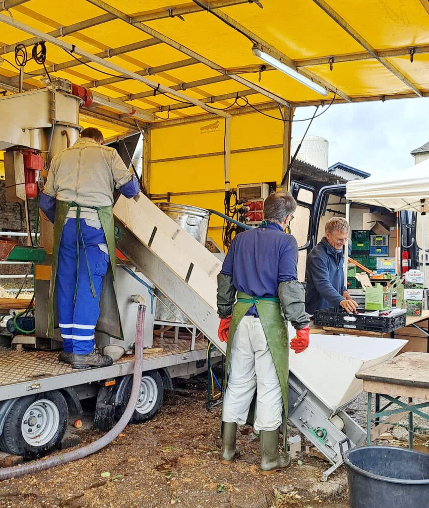 Die mobile Saftpresse des Streuobstnetzwerks Nordeifel eG („SoNNe“) kam zur aktuellen Apfelernte in Wachendorf zum Einsatz, fachkundig bedient von Bernd Schiehlen und Willi Zervos. Sage und schreibe 3,5 Tonnen Früchte wurden in Wachendorf vor Ort zu Saft verarbeitet. Foto: Bürgerverein Wachendorf/pp/Agentur ProfiPress