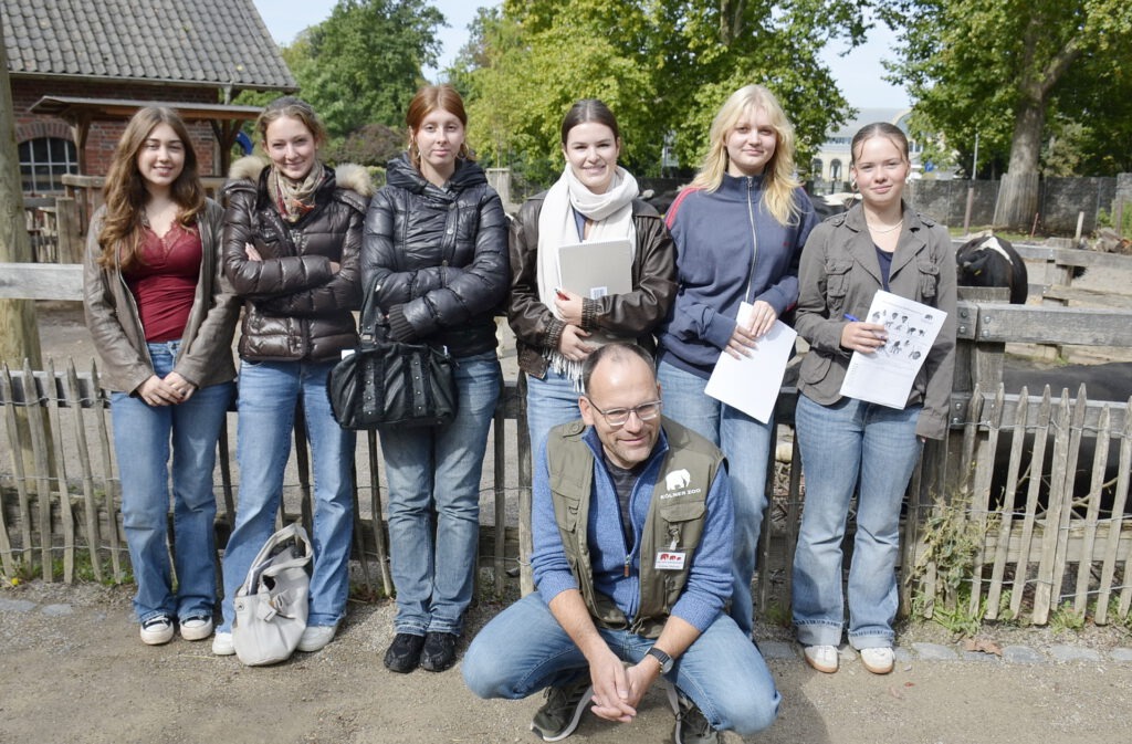 Mit Klemmbrettern und Skizzenbögen vor einem Kuhgehege der Kölner Zoo-Landwirtschaft: Teilnehmerinnen des Projektkurses Biologie der Qualifikationsphase Q1 (früher 11. Klasse) des Gymnasiums Am Turmhof (GAT) in Mechernich sammelten bei einem Kompakttag in der Zooschule Köln Forschungserfahrungen zwischen Elefanten und Flusspferden. Foto: Georg Hastenrath/GAT/pp/Agentur ProfiPress