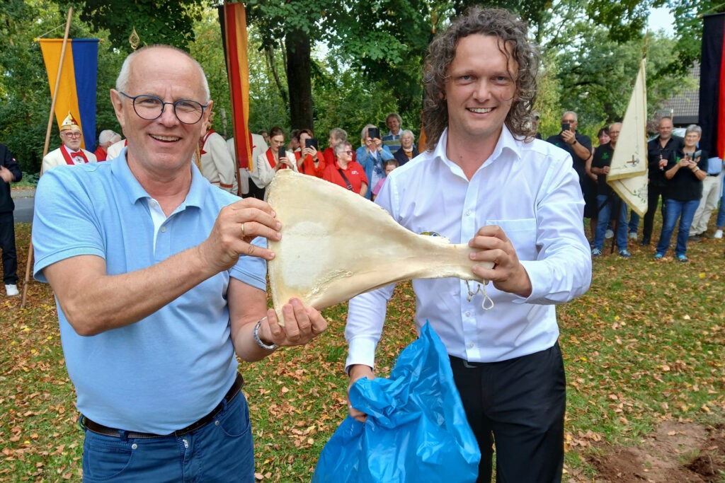 Clever: Weil man zum Feiern laut Sascha Suikerland Geld und gute Freunde braucht, durften Kämmerer Ralf Claßen (l. Geld) und Björn Schäfer vom Vereinskartell Kommern (gute Freunde) den Kirmesknochen ausgraben. Foto: privat/pp/Agentur ProfiPress