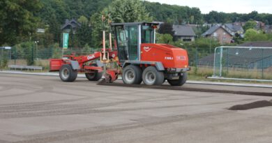 Mit dem Grader wird aktuell eine feine Lavaschicht eingeebnet. Auf sie kommt die elastische Tragschicht, die den Kunstrasen hält. Damit er nicht verrutscht, werden pro Quadratmeter 25 Kilogramm Sand verteilt. Foto: Kerstin Rottland/pp/Agentur ProfiPress