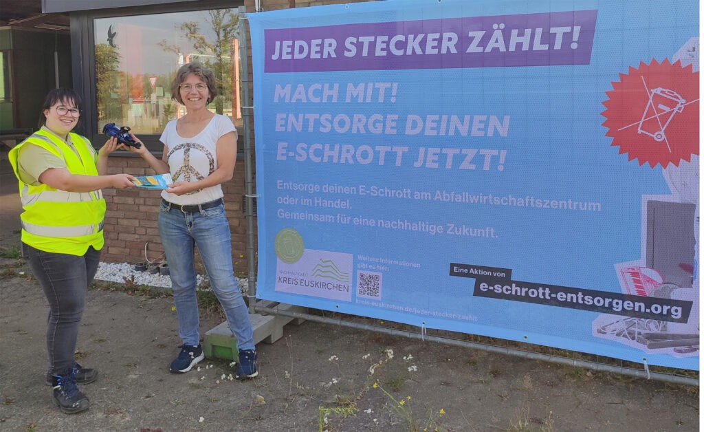 Für mitgebrachten Elektroschrott, wie den kaputten Föhn, bekommt Ruth Claudia Ude (l.) von AWZ-Mitarbeiterin Brigitte Ohlerth eine Samentüte mit bienen- und schmetterlingsfreundlichem Saatgut geschenkt. Foto: Karen Beuke/Kreis Euskirchen/pp/Agentur ProfiPress