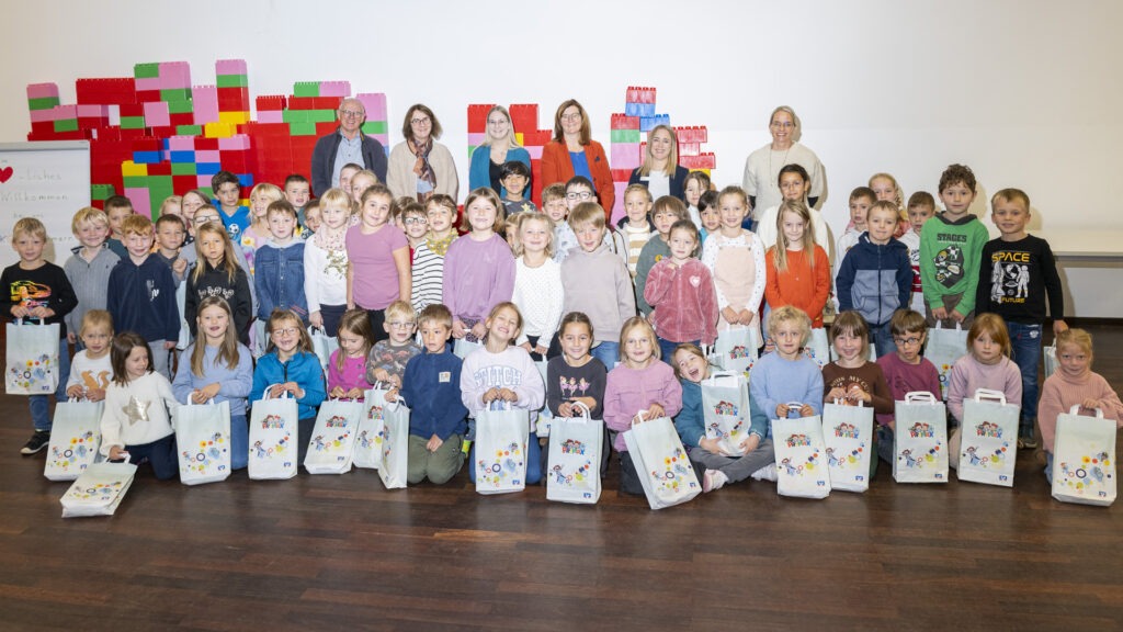 Auch in Kommern freuen sich die rund 60 Erstklässlerinnen und Erstklässler über die Spende der Volksbank Euskirchen. Schulleiterin Tanja Feuser (hinten r.) bedankte sich im Namen aller Schulen. Foto: Ronald Larmann/pp/Agentur Profipress