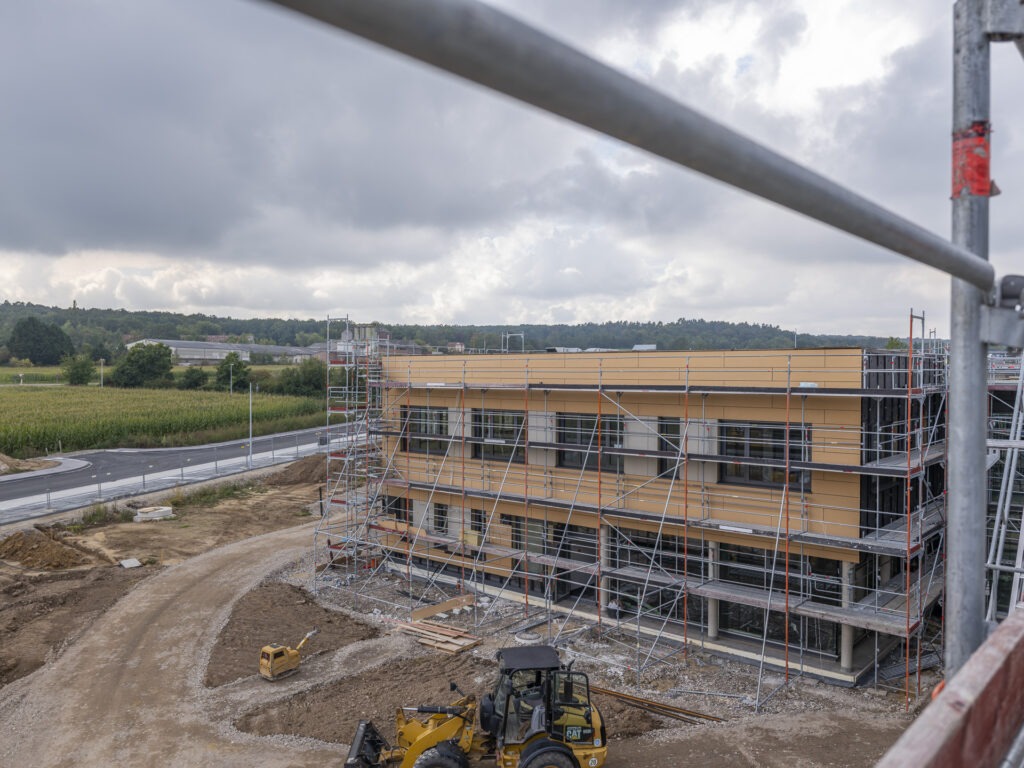 Rund herum eingerüstet ist das Gebäude, damit die Außenfassade noch montiert werden kann. Die Schule wird künftig Gemeinschaftsgrundschule Firmenich-Obergartzem heißen. Foto: Ronald Larmann/pp/Agentur ProfiPress