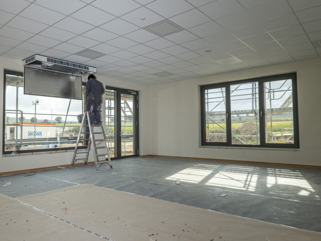 In einem der Klassenräume wird noch an der Lüftung gearbeitet. Unter der Abdeckung ist der Boden schon fertig. Mit Fensterbänken, Tischen, Stühlen und Tafel fehlt nicht mehr viel zum fertigen Raum. Foto: Ronald Larmann/pp/Agentur ProfiPress