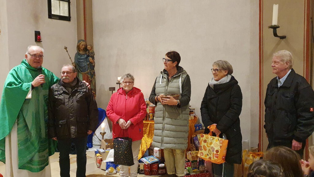 Pfarrer Erik Pühringer und „Tafel“-Chef Wolfgang Weilerswist (v.l.) mit weiteren Vorständen der Mechernicher Wohltätigkeitsorganisation mit gespendeten Lebensmitteln der Gemeindemitglieder am Altar der Pfarrkirche St. Johannes Baptist. Archivfoto: pp/Agentur ProfiPress