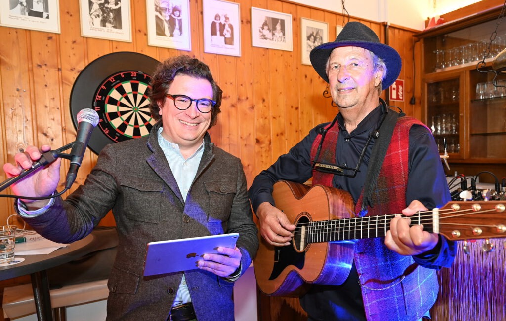 Ronald Larmann, Moderator und Leiter der Mechernicher Agentur ProfiPress, und sein singender und Gitarre und Mundharmonika spielender Spannmann Günter Hochgürtel („Wibbelstetz“, Troubadour“ und „Eifel-Gäng“) inszenierten einen kurzweiligen und stimmungsvollen Abend. Foto: Manfred Lang/pp/Agentur ProfiPress
