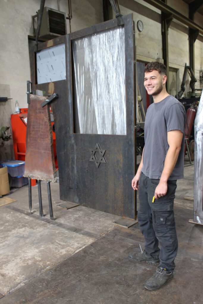 Der 23-jährige Metallbaumeister Jannis Müller aus Hostel schuf das neue Mahnmal aus Cortenstahl, in das die bisherige Stele und auf ansprechende Weise künstlerisch integriert wurde.
Foto: Kerstin Rottland/pp/Agentur ProfiPress