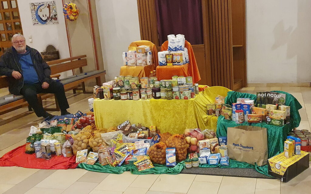 Diesen Gabentisch in der Pfarrkirche St. Johannes Baptist deckten die Gottesdienstbesucher, wie hier Werner Zeyen, mit haltbarem Lebensmittelspenden für die versorgungsbedürftigen Personen, die die Mechernicher Tafel betreut. Foto: Claudia Simon/pp/Agentur ProfiPress