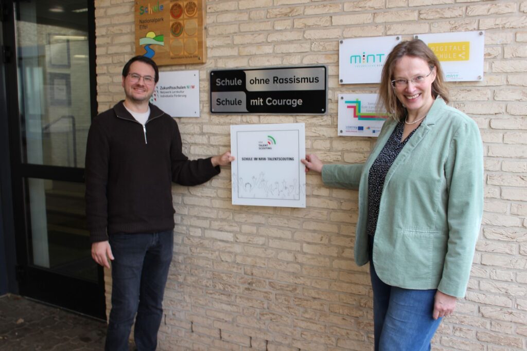 Neue Auszeichnung für die Gesamtschule: Wo die Plakette hinsoll, zeigen Lehrer Patrick Wloka und Schulleiterin Sandra Köhn. Foto: Kerstin Rottland/pp/Agentur ProfiPress