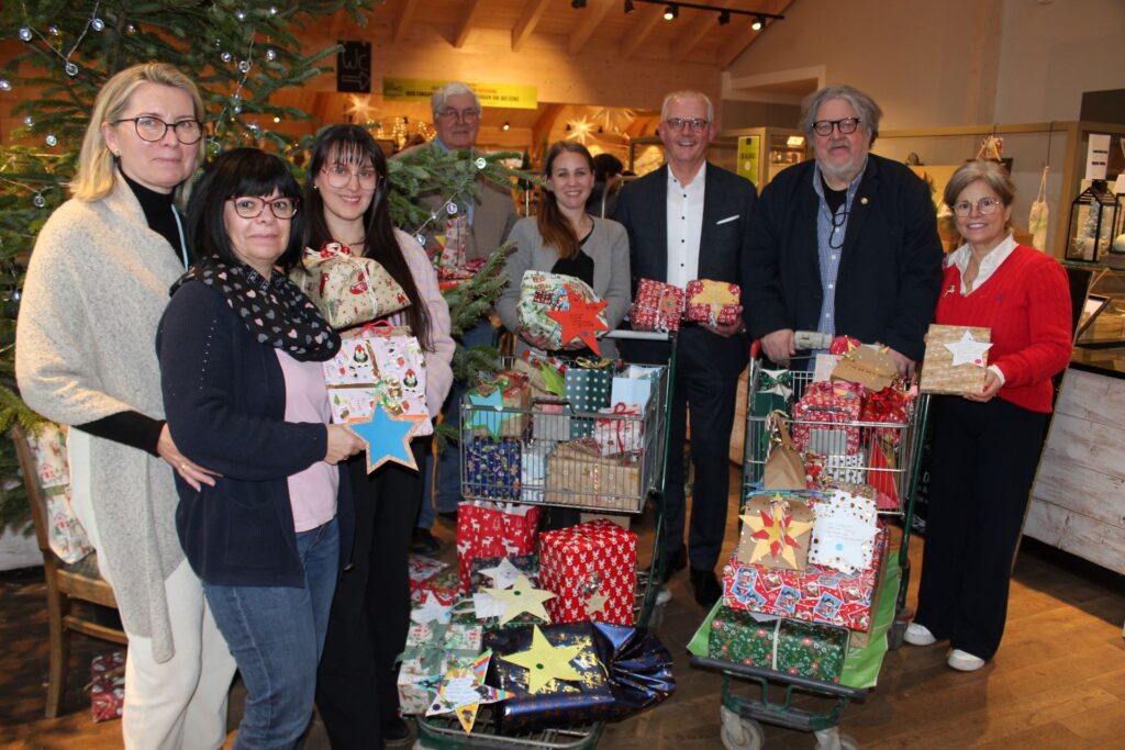 Strahlende Gesichter unterm Baum: Der Vorstandsvorsitzende der KSK-Euskirchen, Holger Glück (3.v.r.) sowie Danielle (r.) und Theo (4.v.l.) Bieger unterstützten die Mitarbeiterinnen des Euskirchener Kinderschutzbunds Petra Marian, Sabina Kronhof, Lena Wefers (v.l.) und den Geschäftsführer des Kinderschutzbundes im Kreis Euskirchen, Bernd Kolvenbach (2.v.l.), plus Stellvertreterin Sara Könen-Krolos (4.v-r.). Foto: Kerstin Rottland/pp/ Agentur ProfiPress